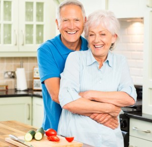 Happy Senior Couple Embracing In Kitchen.